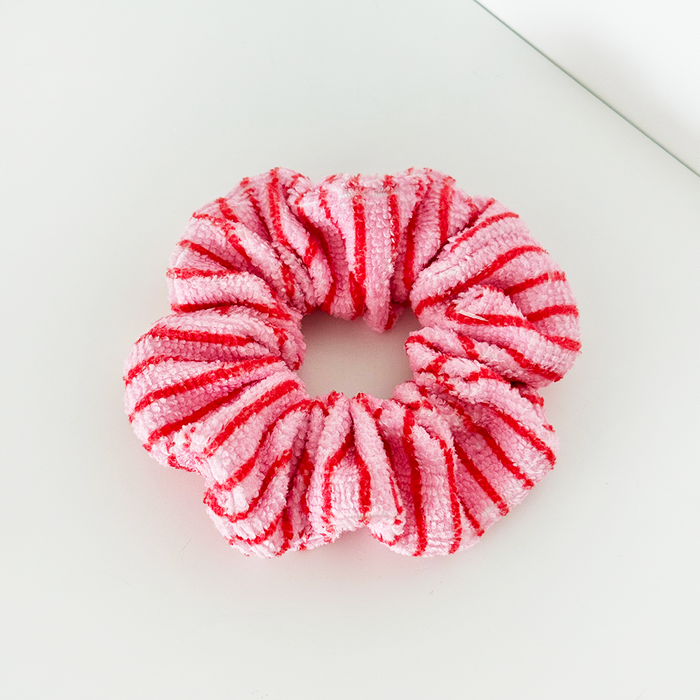Cherry Stripes scrunchie with red and white pattern resting on a white surface.