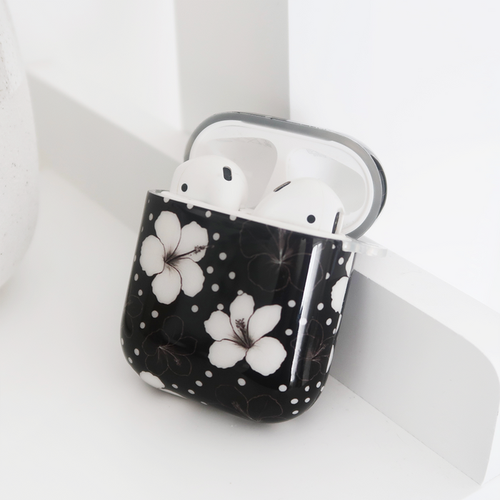Mono Flora AirPods case by Coconut Lane with white earbuds, shown on a white surface.