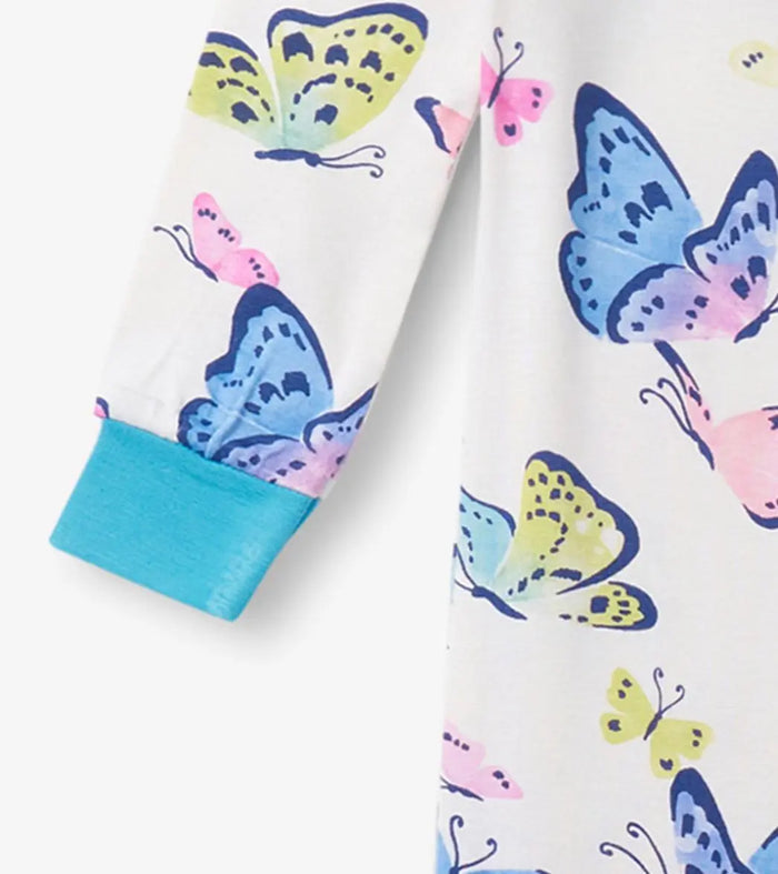 Sleeve detail of bamboo baby sleeper with butterfly print and aqua cuff.