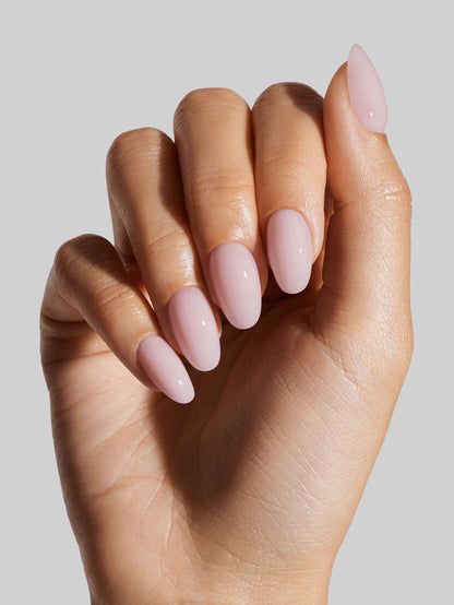 Hand with pink nail polish on a neutral background