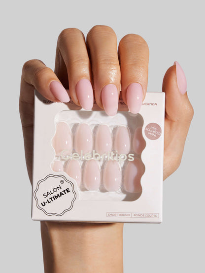 Hand holding a box of press-on nails with 'Salon U-ltimate' branding on a light gray background