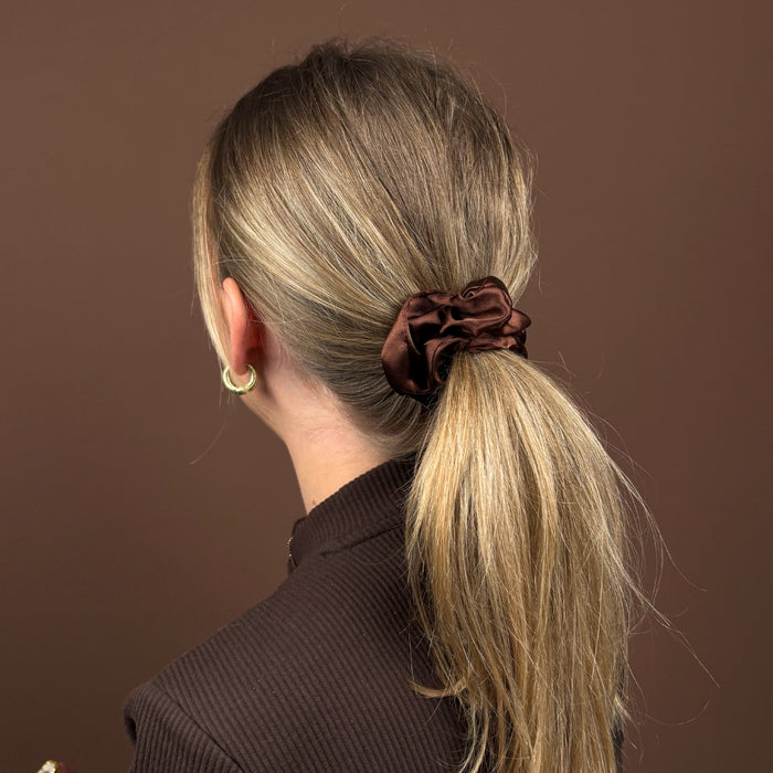 Blonde woman facing away wears a brown Coconut Lane scrunchie in a low ponytail.