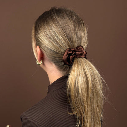 Blonde woman facing away wears a brown Coconut Lane scrunchie in a low ponytail.