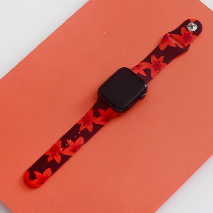 Smartwatch with Coconut Lane Cinnamon Lily strap on a peach background; strap features a floral pattern in warm tones.