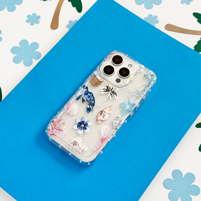 Coconut Lane clear phone case with Beach Girl Summer design on a blue surface, floral print in background.