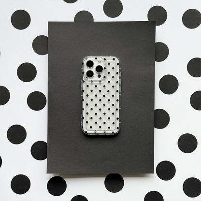 Clear phone case with black polka dots by Coconut Lane, displayed on a matching black and white polka dot background.