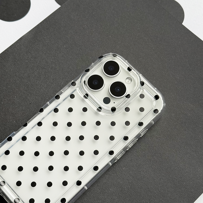 Clear phone case with black polka dots by Coconut Lane, displayed on a black and white background.