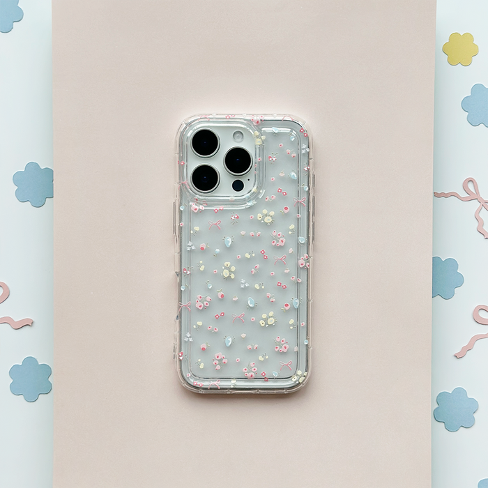 Clear phone case with pastel flower and ribbon pattern on a pink background.
