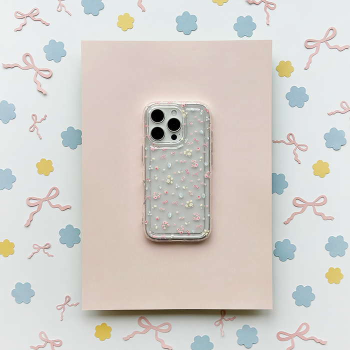 Clear Coconut Lane phone case with pastel bows and blue flower cutouts in a floral pattern.