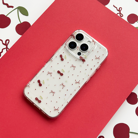 Clear phone case with a ditsy pattern of red cherries and small bows on a transparent background.
