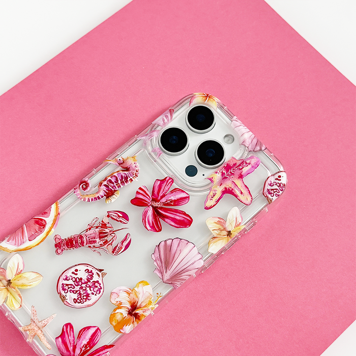 Clear phone case with pink seashell and flower pattern, shown on a smartphone against a pink background.