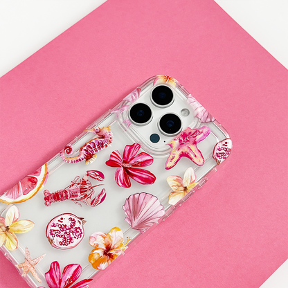 Clear phone case with pink seashell and flower pattern, shown on a smartphone against a pink background.