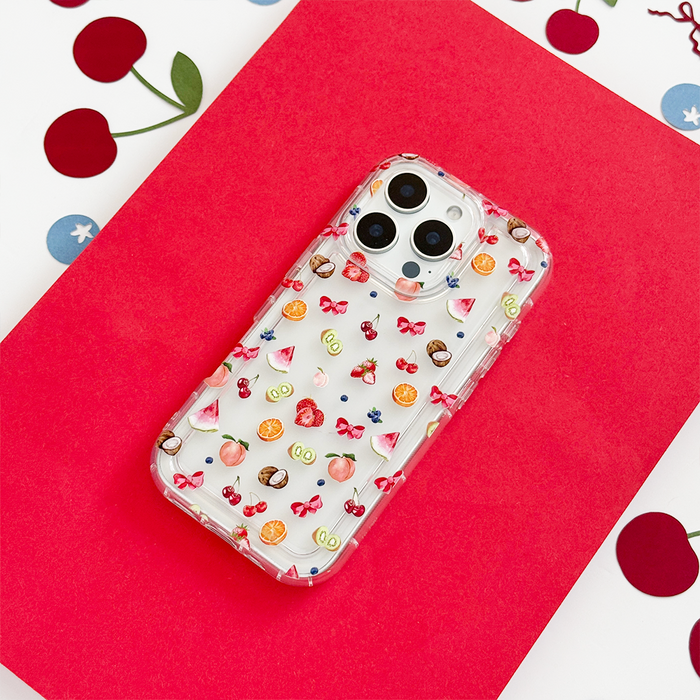 Clear phone case with colorful fruit design on a bright red cherry-patterned surface.