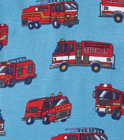 Closeup of Hatley boys Firetrucks pajama print showing red trucks on blue organic cotton fabric.