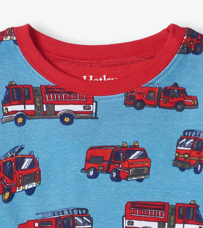 Closeup of Hatley boys pajama top with red neckline, Firetrucks print, and Hatley logo.
