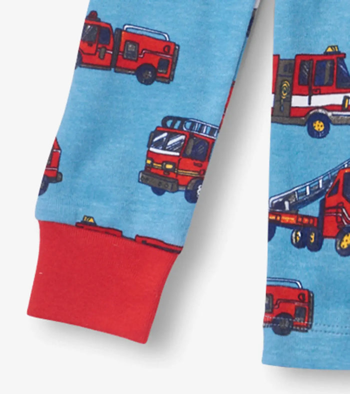 Closeup of Hatley boys pajama cuff with red trim and Firetrucks organic cotton fabric.
