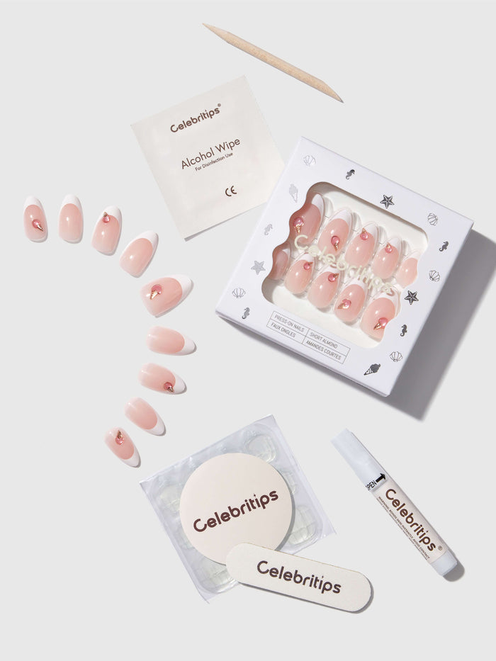 Nail art kit with press-on nails, alcohol wipe, and applicator on a white background