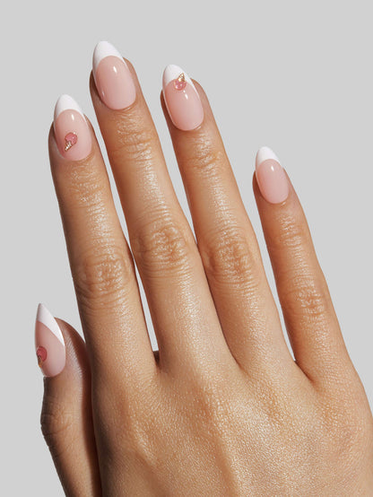 Hand with pink press-on nails on a plain background