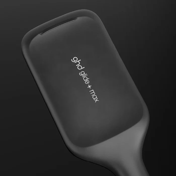Black hair straightener with 'ghd' branding on a dark background