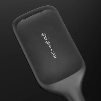 Black hair straightener with 'ghd' branding on a dark background
