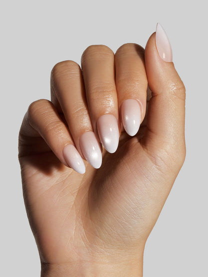 Hand with light pink press-on nails on a neutral background