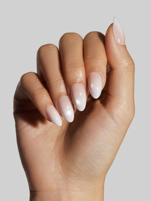Hand with light pink press-on nails on a neutral background