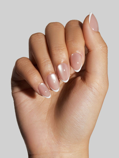 Close-up of a hand with neutral press-on nails with a white tip on a neutral background