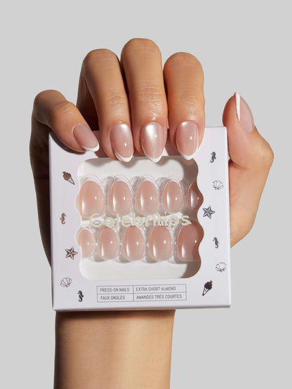 Hand holding a box of In Crystal Halo press-on nails with a neutral background