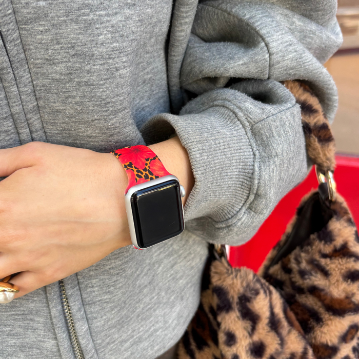 Person in gray sweatshirt wears a leopard-print Apple Watch strap and holds a matching leopard-print bag.