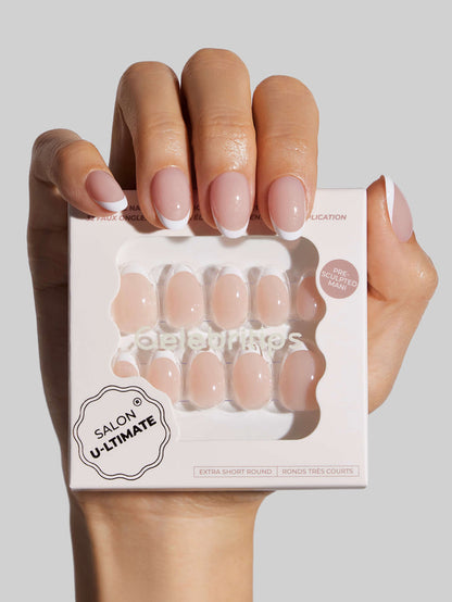 Hand holding a box of 'Salon U-Ltimate' false nails against a neutral background