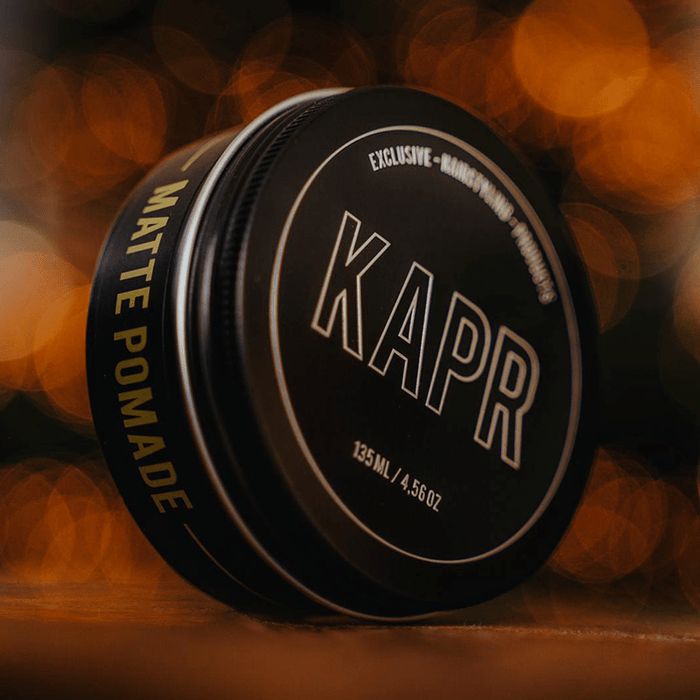 Detailfoto KAPR Matte Pomade – stijlvolle zwarte verpakking met gele gloed.