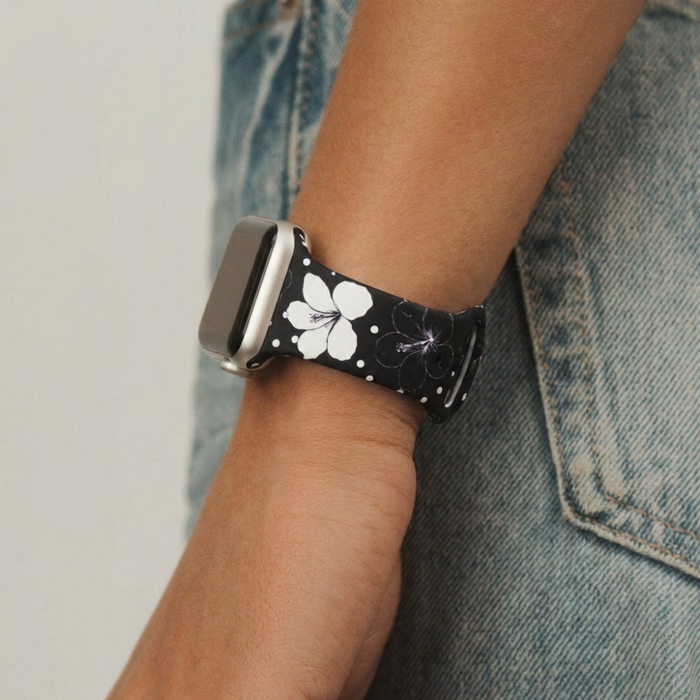 Coconut Lane Mono Flora Apple Watch strap with a black and white floral pattern, worn with light blue denim jeans.