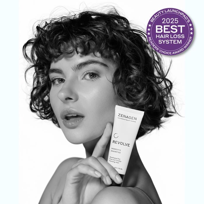 Model holding Zenagen Revolve women’s shampoo, professional hair care product for fine and visibly thinning hair appearance.