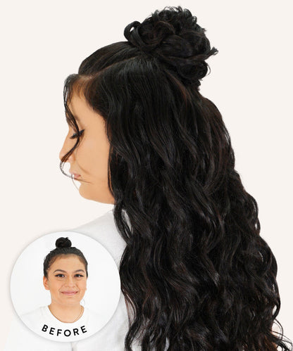 A woman with long, wavy black hair styled half-up in a bun showcases her look using Perfect Locks Scrunchie Hair Extensions.