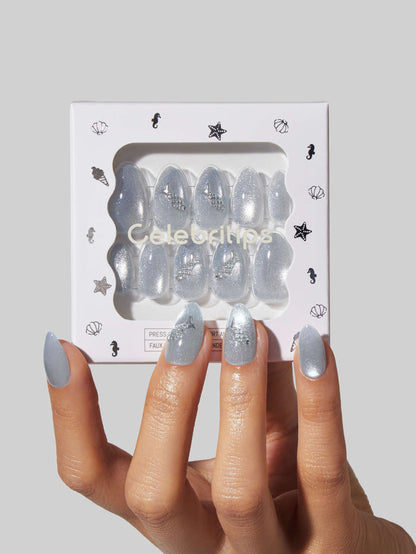 Hand holding a package of Sea Salt press-on nails with 'Celebritips' branding on a light gray background