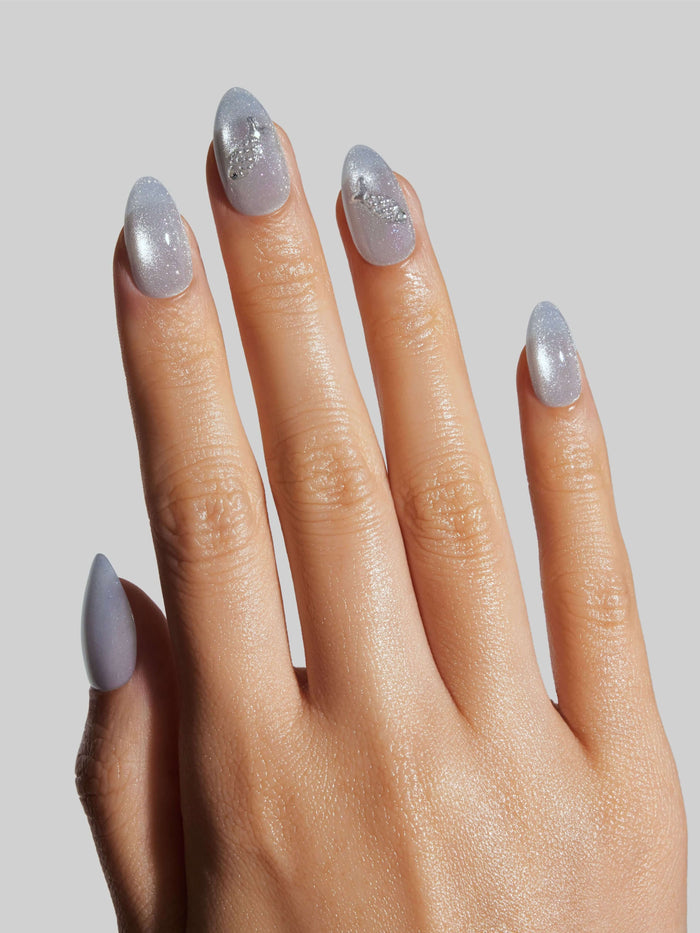 Hand with sparkly press-on nails on a plain background