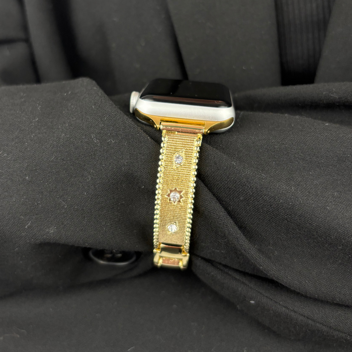 Gold Shimmer Star Apple Watch strap by Coconut Lane displayed on a black fabric background.