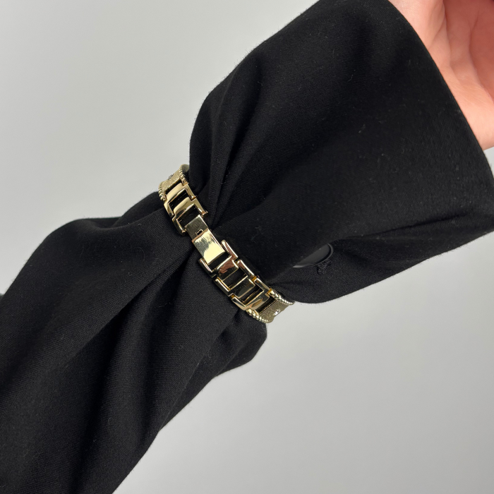 Gold Shimmer Star Apple Watch strap by Coconut Lane holding a black scarf, shown against a grey background.