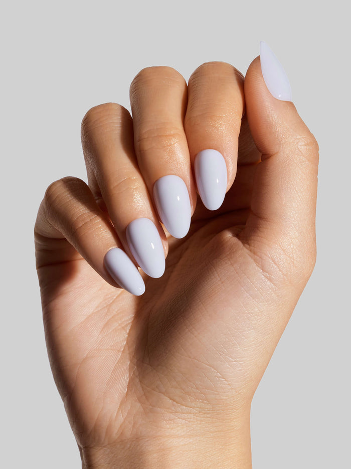 Hand with sky blue press-on nails on a neutral background