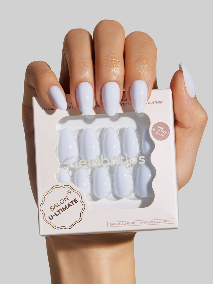 Hand holding a box of blue press-on nails with Salon U-ltimate branding.