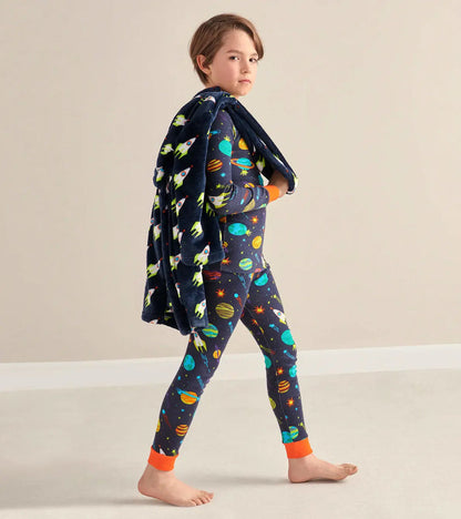 Boy walking in Hatley boys space pajamas with full-length pants and orange contrast trim.