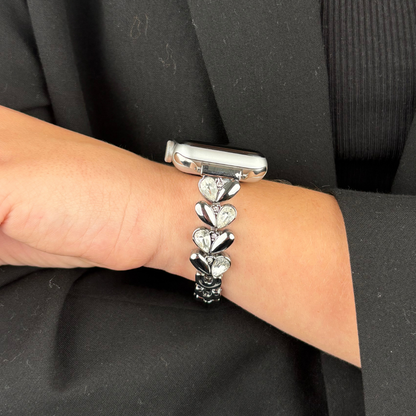 Silver Sparkle Petal Apple Watch strap with a shimmering finish and petal pattern, shown alongside a black outfit.