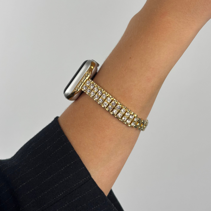 Gold Coconut Lane Sparkle Season Apple Watch strap on wrist, shown against a simple plain background.