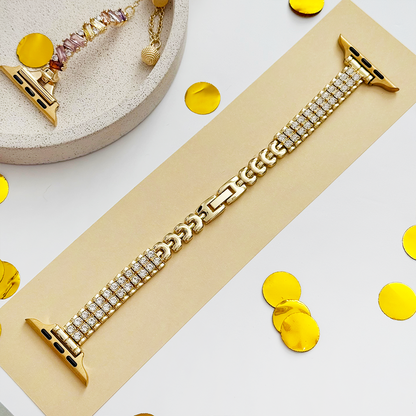 Gold Apple Watch strap with a subtle sparkle, displayed on a beige card scattered with gold confetti.