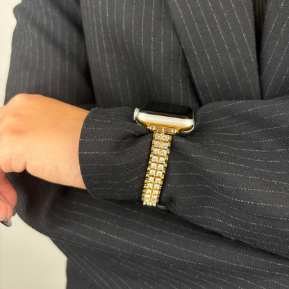 Gold Coconut Lane Sparkle Season Apple Watch strap on wrist, paired with a pinstripe suit.