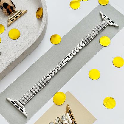 Starlight Apple Watch strap with a subtle shimmer, displayed on gray with gold confetti and matching accessories.