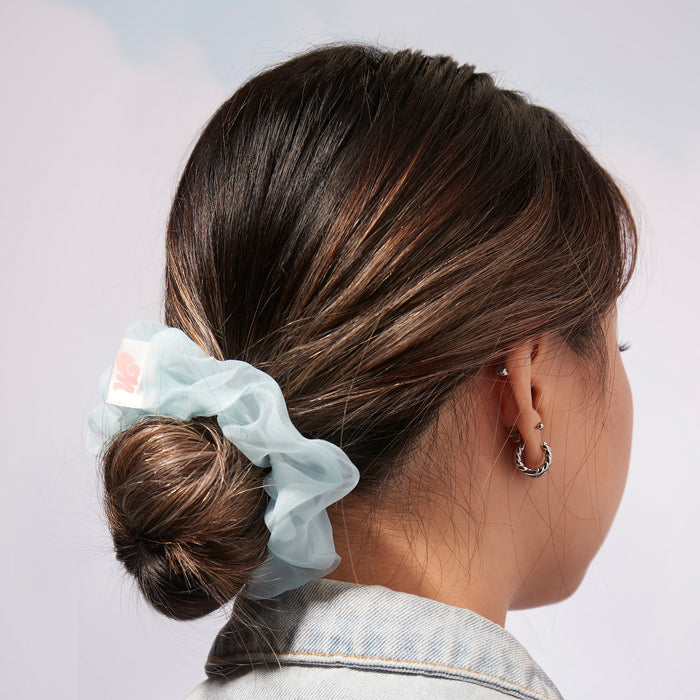 Woman with hair in low bun tied with blue Blue and yellow Sugar Cloud Scrunchie