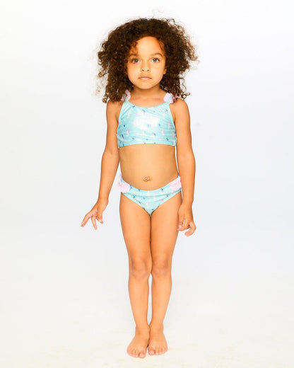 Girl wearing Deux par Deux blue seahorse two-piece swimsuit for a sunny pool or beach day.