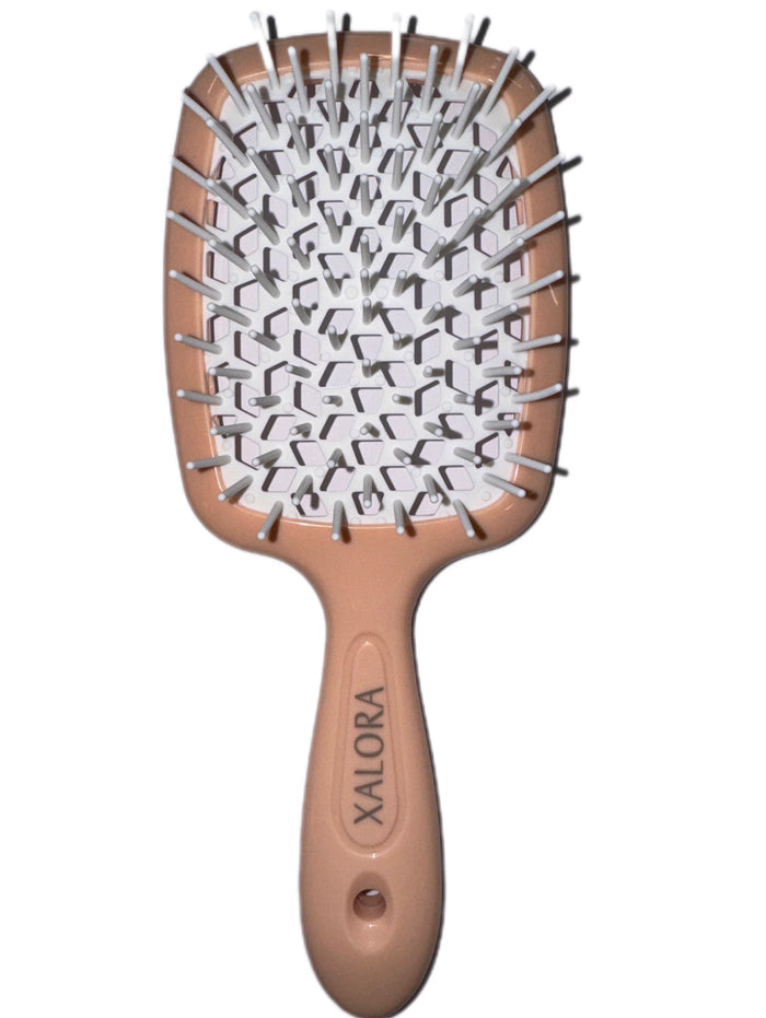 Hairbrush with a brown handle and white bristles on a white background
